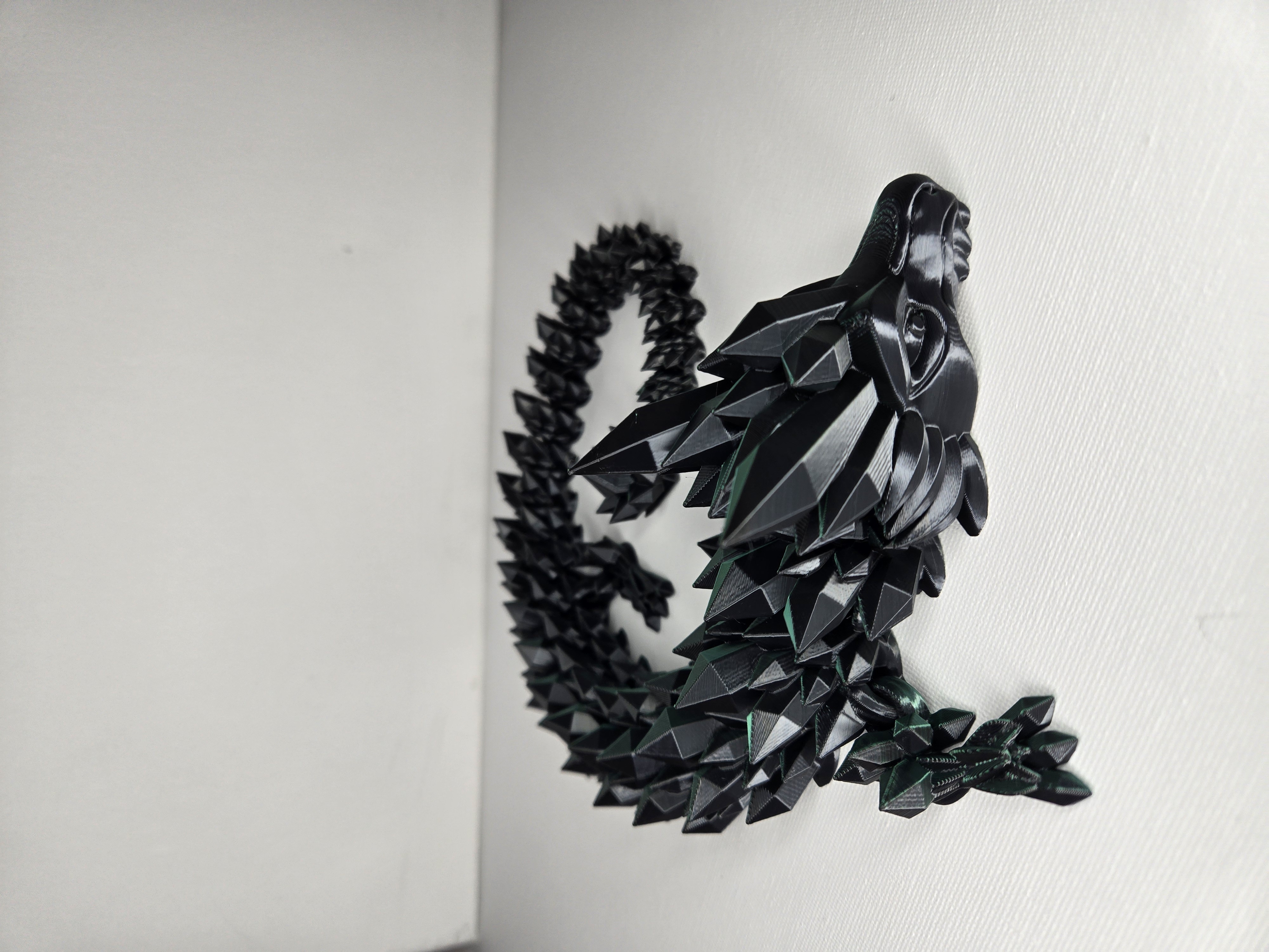 3D printed articulated kryptonite dragon in dark black with geometric spiked scales